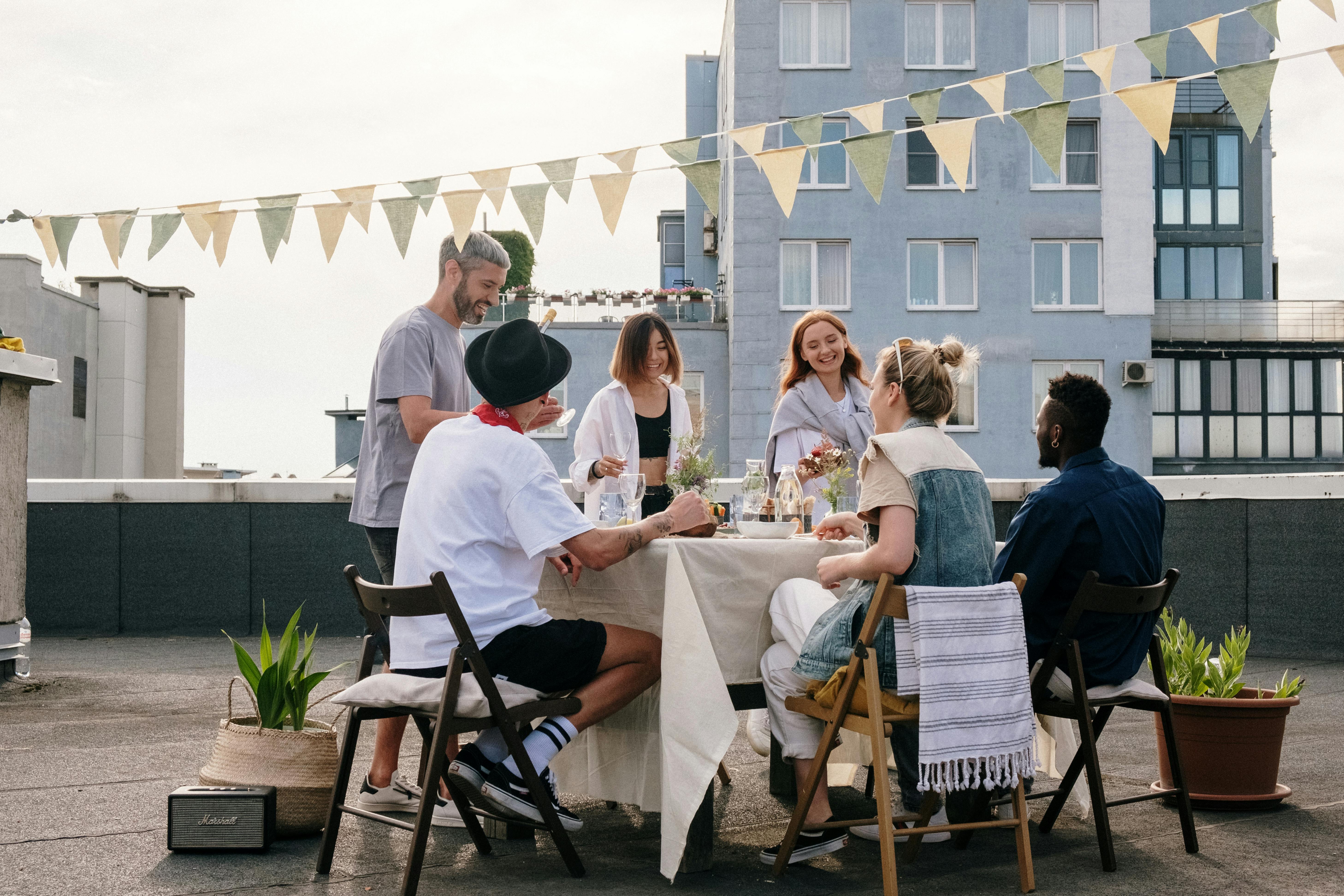 Friends gathered around a rooftop dinner table